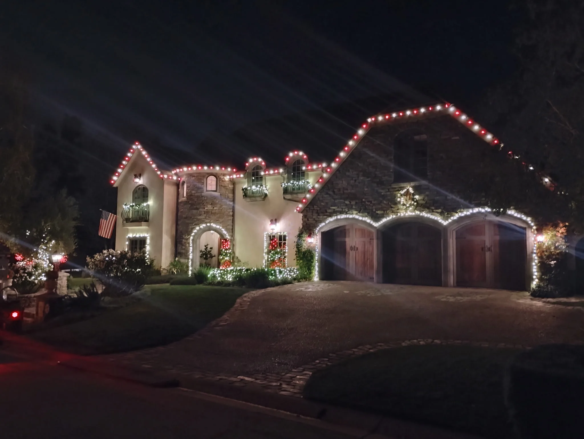 Mediterranean estate lit with red and warm-white C9 Christmas lights by Bee Merry in Thousand Oaks