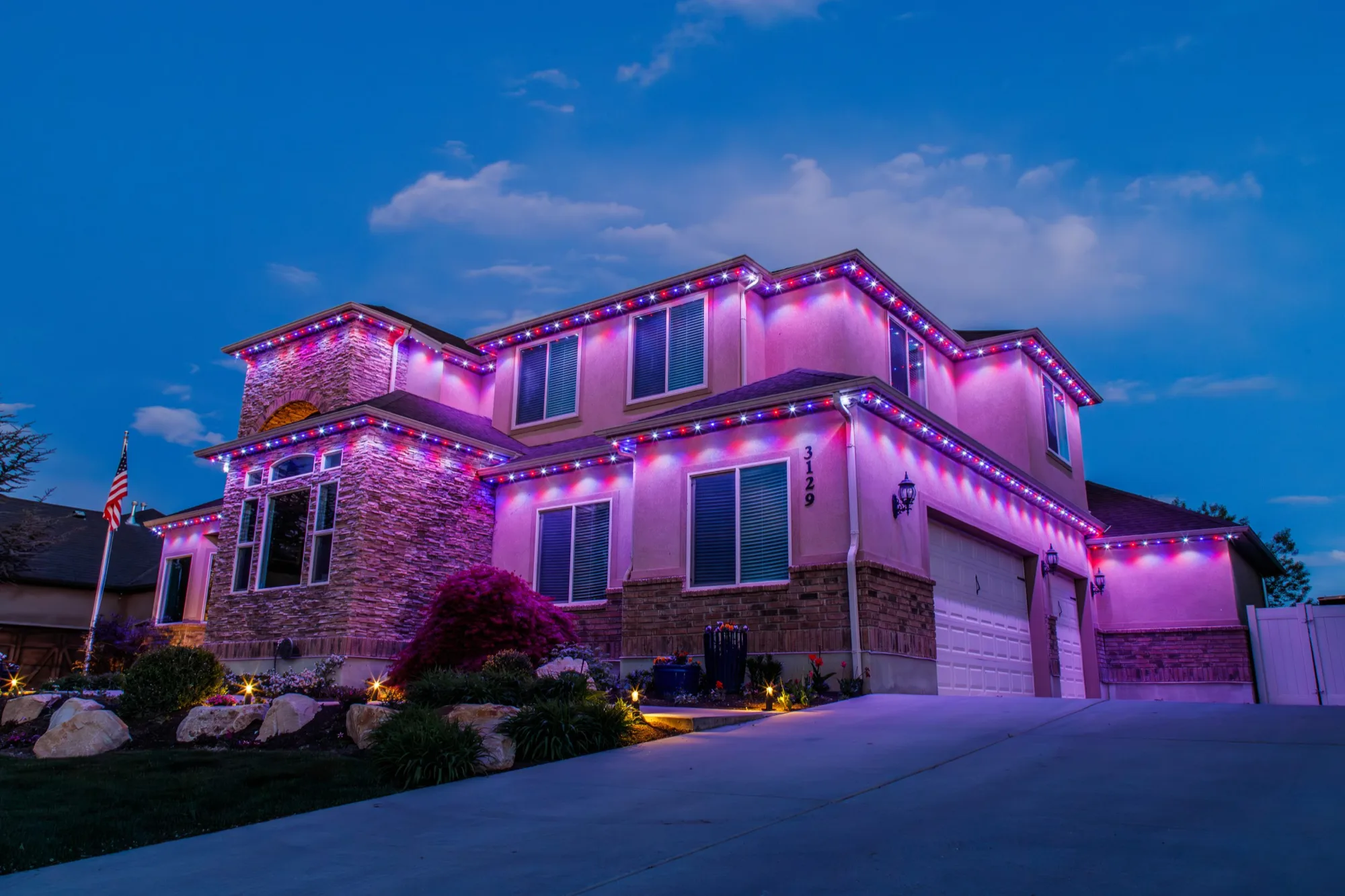 Estate glowing with RGB Christmas lights at blue hour, installed by Bee Merry