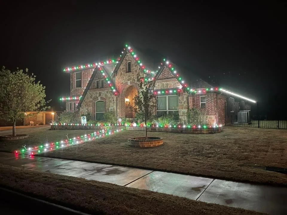 Stone home with red, green and white C9 Christmas lights installed by Bee Merry